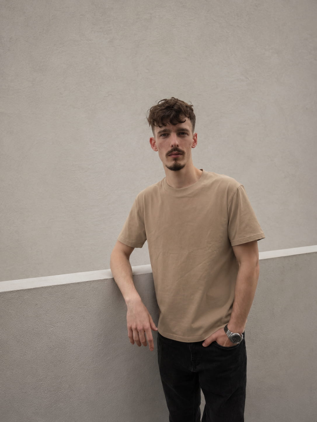 Khaki — The Loose Standard worn against a wall