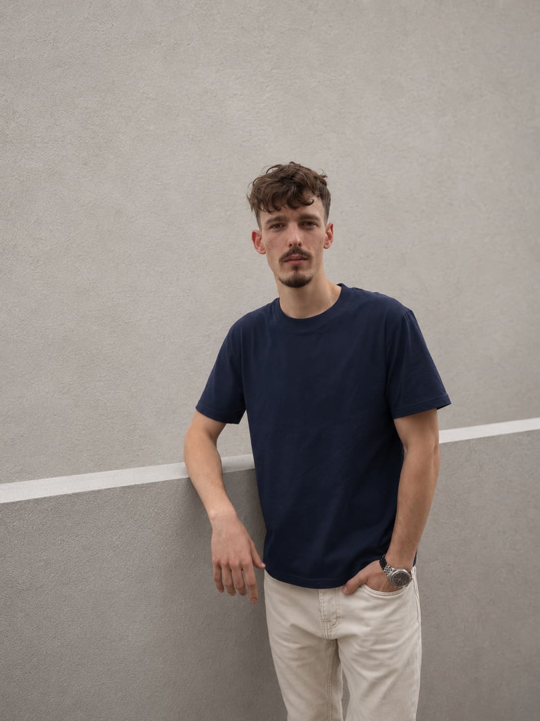 Navy Blue — The Loose Standard worn against a wall