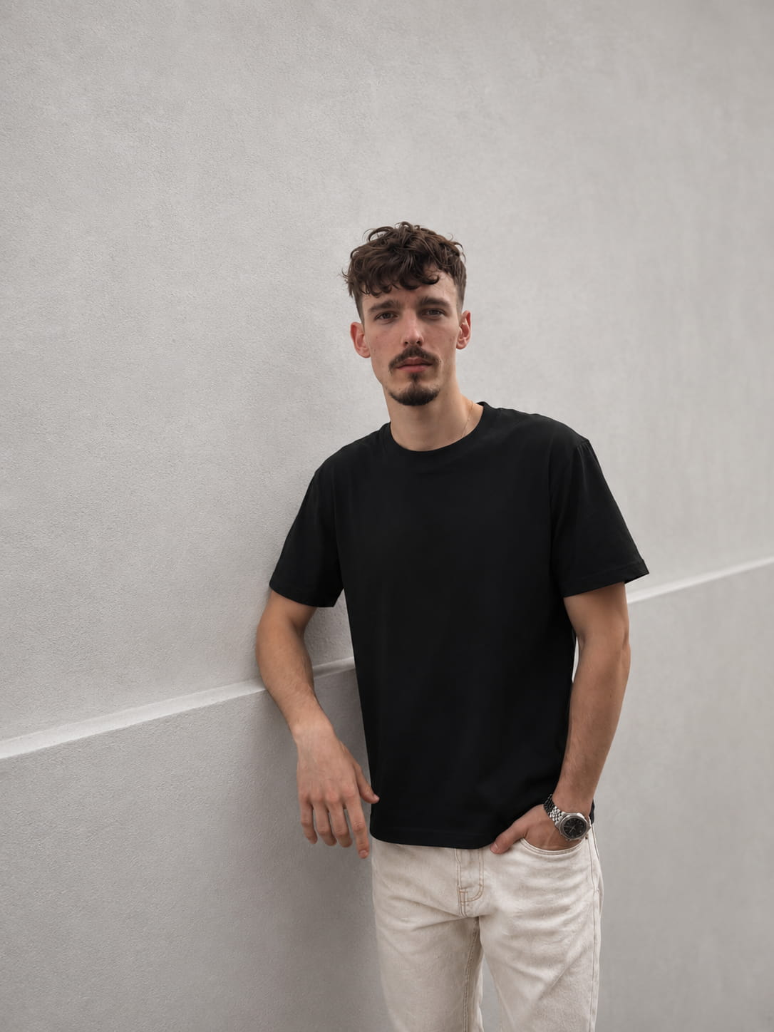 Black — The Loose Standard worn against a wall