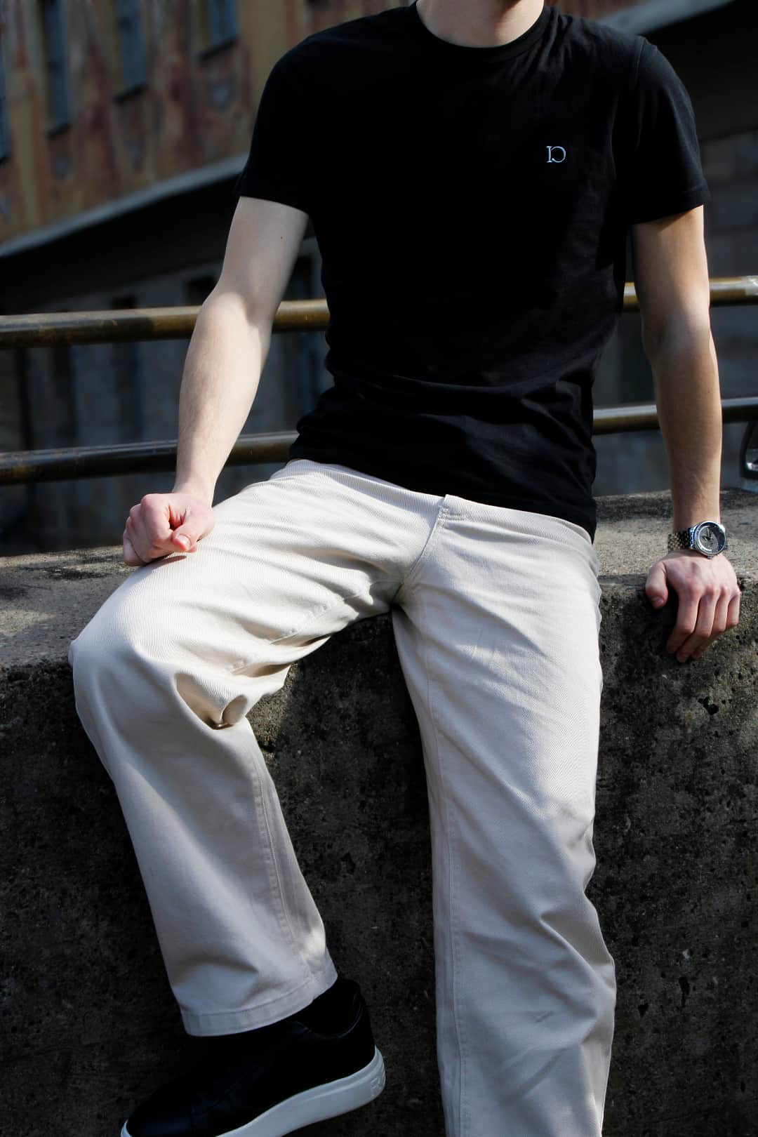 The Standard Trousers in pale khaki, worn seated